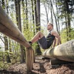 Germany, Coburg, Young man at training on a fitness trail in a forest