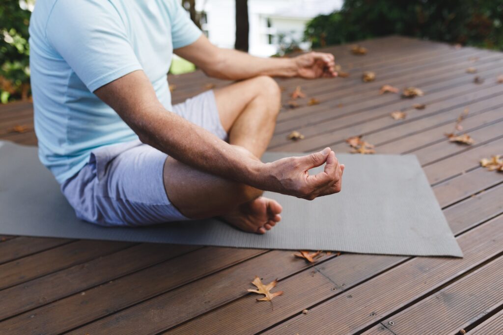 Relaxed senior caucasian man practicing yoga, meditating in garden